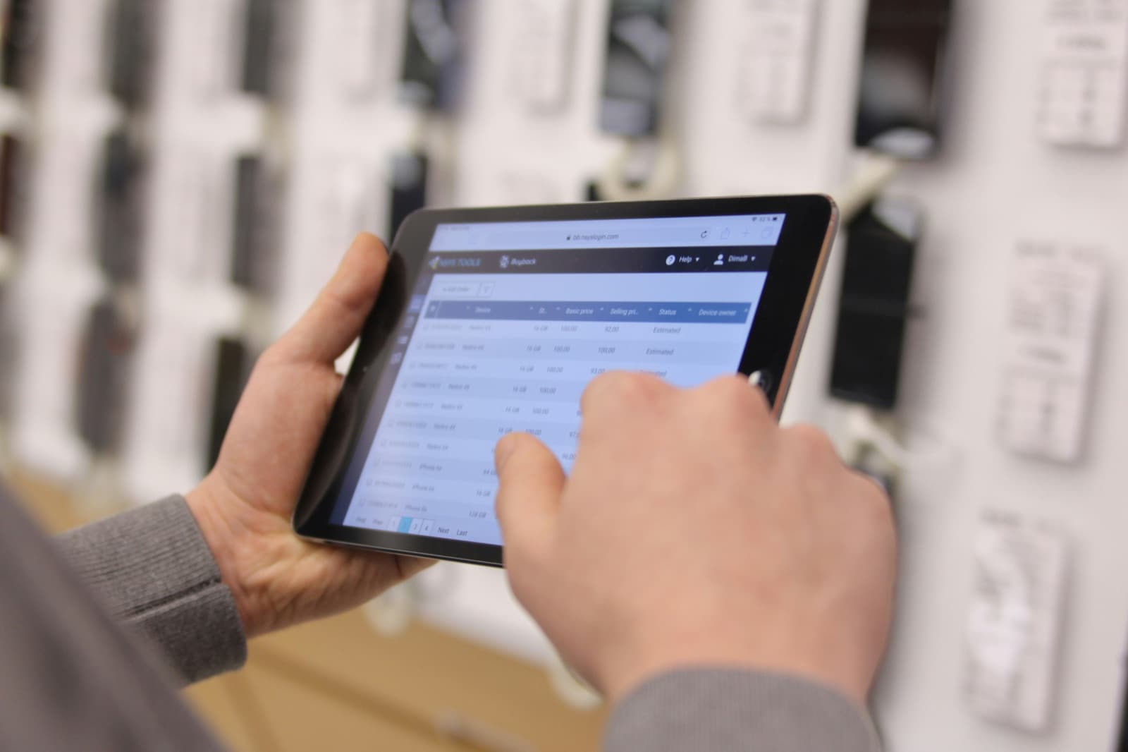 Person tippt auf einem Tablet mit einer digitalen Auftragsübersicht